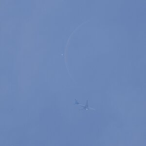 Ein Flugzeug vor der Venus und dem Mond.