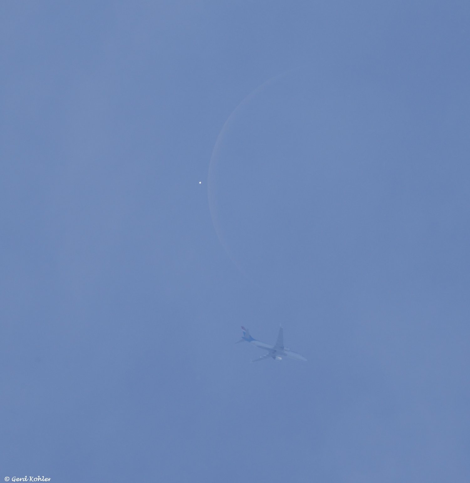 Ein Flugzeug vor der Venus und dem Mond.